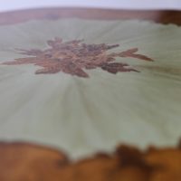 Détail d'une marqueterie sur une table guéridon relookée par La Fée Caséine